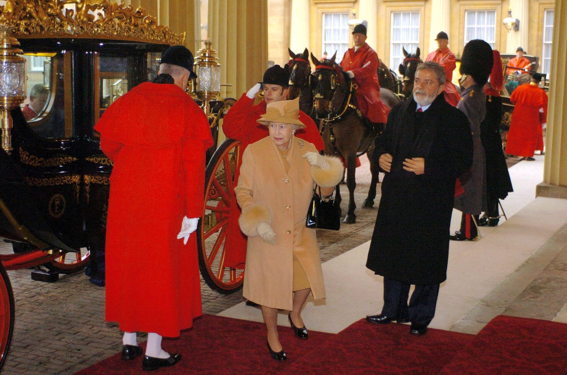 A rainha Elizabeth II chega, ao lado do então presidente do Brasil, Luiz Inácio Lula da Silva (de preto, à direita), ao Palácio de Buckingham, em Londres, em 7 de março de 2006 - Sputnik Brasil, 1920, 08.09.2022