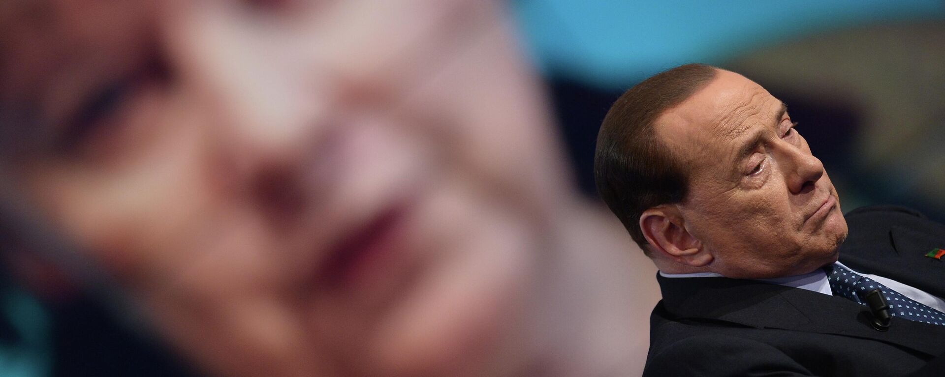 Primeiro-ministro italiano, Silvio Berlusconi perante uma tela mostrando a chanceler alemã Angela Merkel durante o programa de televisão Porta a Porta, 22 de maio de 2014 - Sputnik Brasil, 1920, 09.09.2022