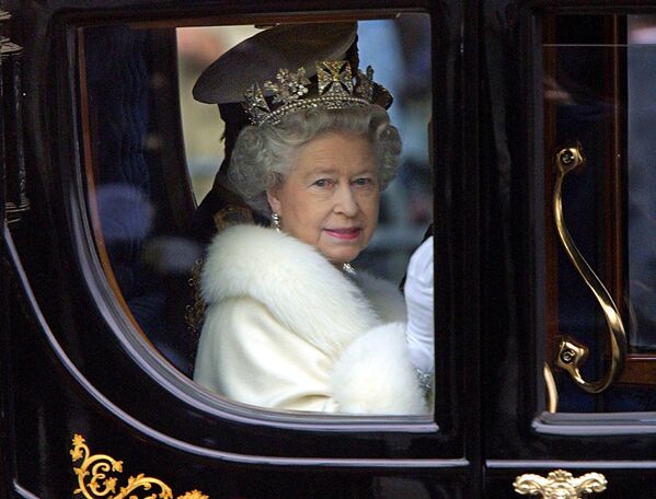 Rainha Elizabeth II em sua carruagem deixando o Palácio de Buckingham para a abertura do Parlamento em Londres, 6 de dezembro de 2000. - Sputnik Brasil