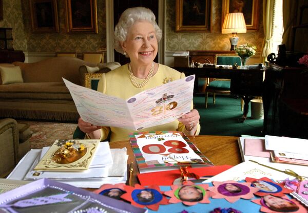 Rainha Elizabeth II senta-se no Palácio de Buckingham, em 19 de abril de 2006, olhando para alguns dos cartões que foram enviados para ela em meio ao seu aniversário de 80 anos. - Sputnik Brasil