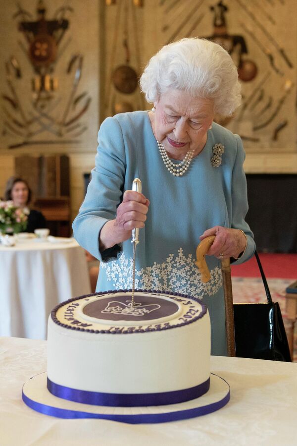 Rainha Elizabeth II corta um bolo para celebrar o início do jubileu de platina, no Sandringham House, sua residência em Norfolk, Reino Unido, 5 de fevereiro de 2022. - Sputnik Brasil