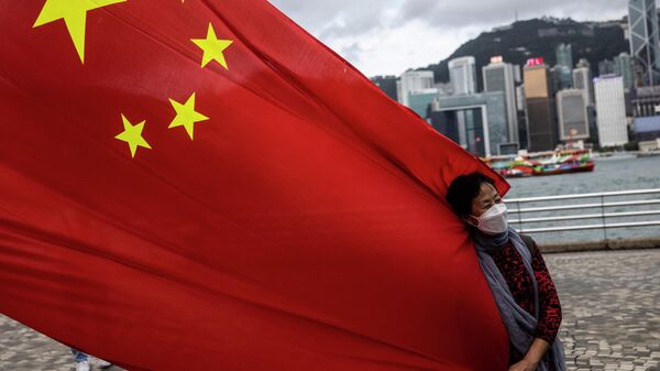 Mulher segura bandeira chinesa no 25º aniversário da entrega da cidade de Hong Kong pelo Reino Unido, Hong Kong, China, 1º de julho de 2022 - Sputnik Brasil