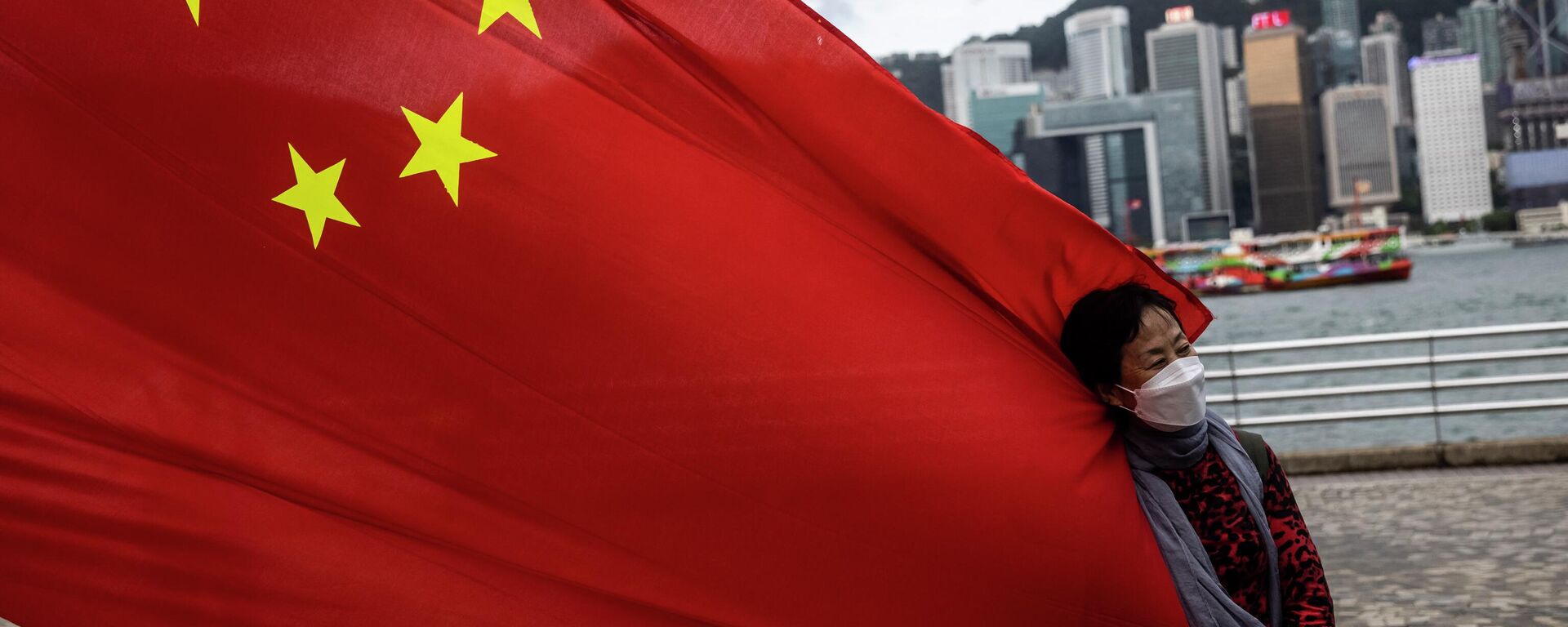 Mulher segura bandeira chinesa no 25º aniversário da entrega da cidade de Hong Kong pelo Reino Unido, Hong Kong, China, 1º de julho de 2022 - Sputnik Brasil, 1920, 18.09.2022