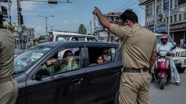 Uma família da Caxemira pede permissão a policial para atravessar estrada perto de posto de controle em Srinagar, no estado de Jammu e Caxemira, na Índia, em 7 de agosto de 2022 - Sputnik Brasil