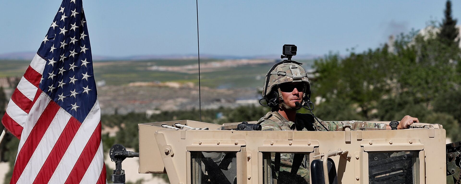 Soldado dos EUA sentado em seu veículo blindado em uma estrada que leva à tensa linha de frente com combatentes apoiados pela Turquia, em Manbij, norte da Síria, 4 de abril de 2018 - Sputnik Brasil, 1920, 21.09.2022