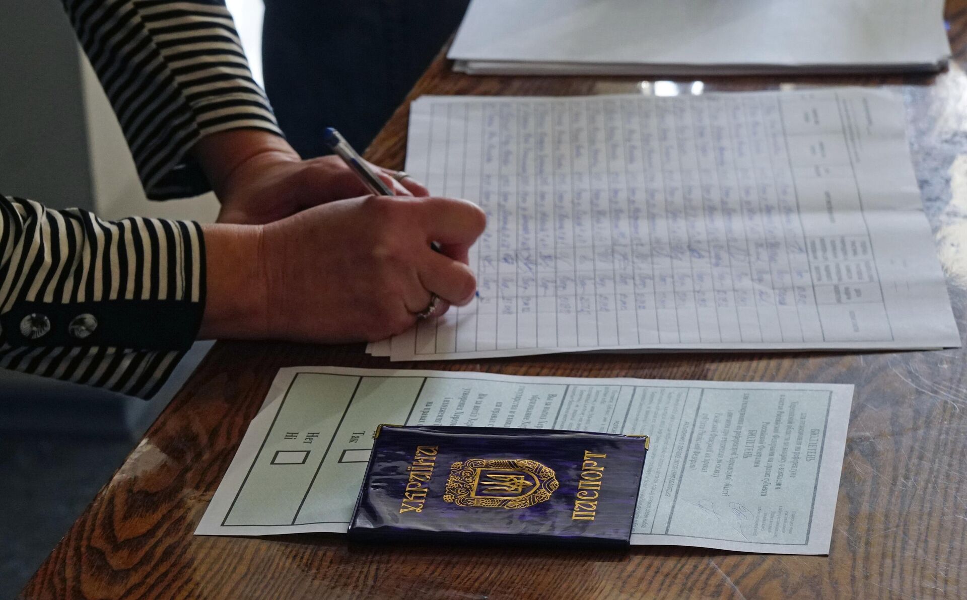 Mulher se registra no local de votação em Kherson no referendo sobre a adesão da região de Kherson à Rússia, em 23 de setembro de 2022 - Sputnik Brasil, 1920, 24.09.2022