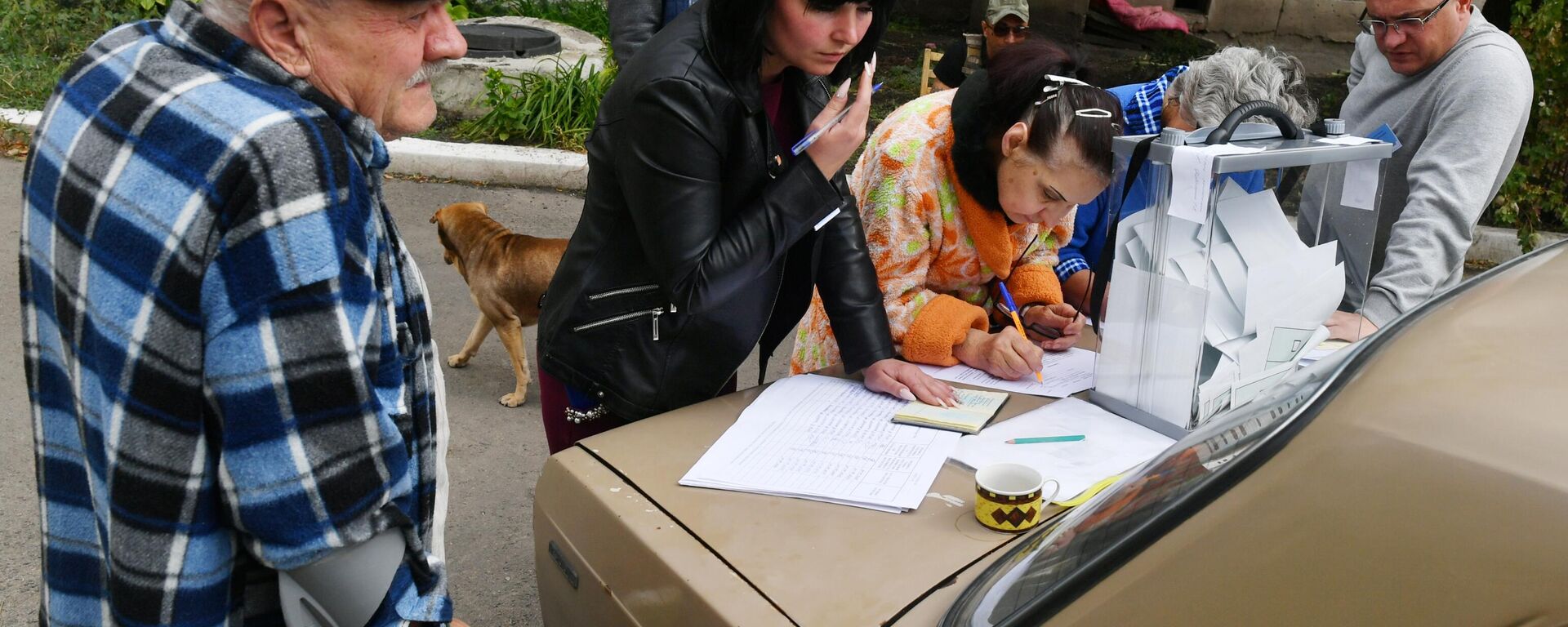 Moradores de Volnovakha, na República Popular de Donetsk, votam no referendo em urna portátil conduzida por funcionários da comissão eleitoral a fim de evitar aglomerações nos locais de votação, em 24 de setembro de 2022 - Sputnik Brasil, 1920, 24.09.2022
