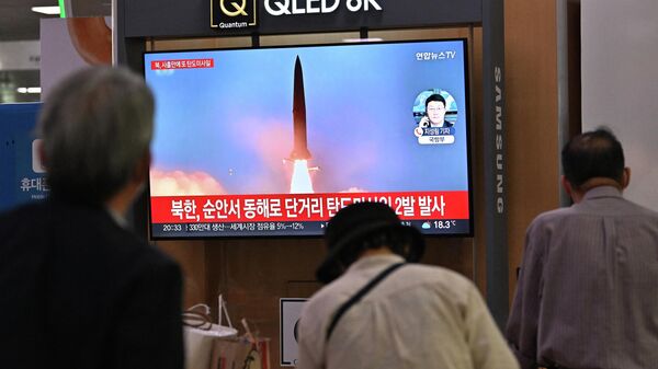 Pessoas observam tela televisiva mostrando lançamento de míssil norte-coreano em uma estação ferroviária de Seul, Coreia do Sul, 28 de setembro de 2022 - Sputnik Brasil