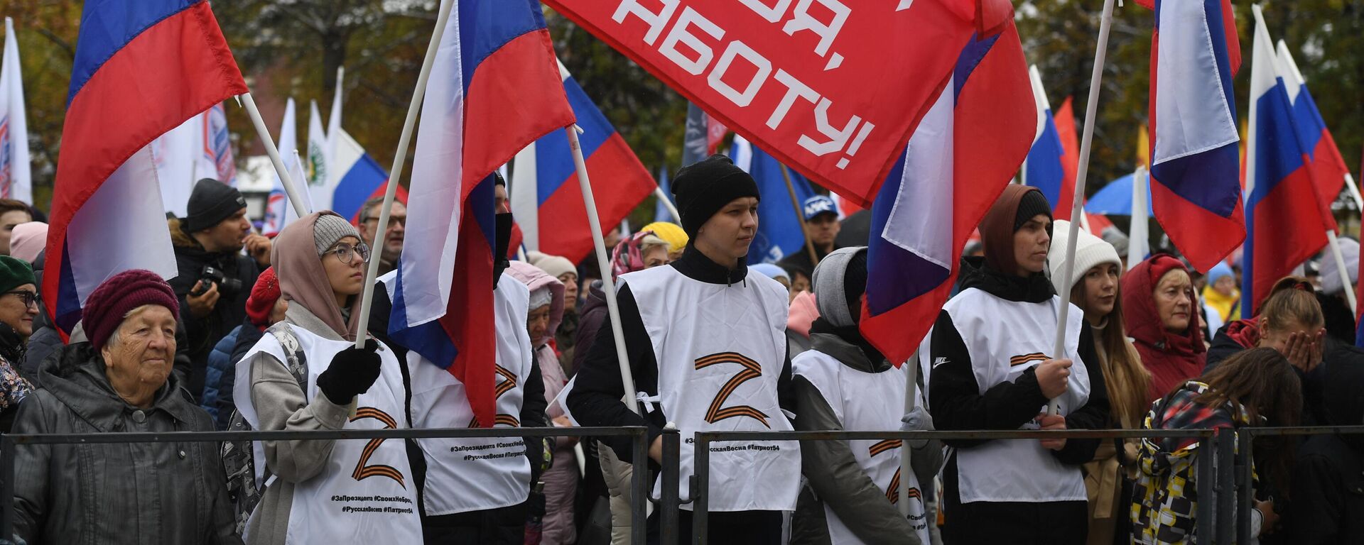Pessoas com bandeiras durante concerto de comemoração da adesão à Rússia das repúblicas populares de Donetsk (RPD) e Lugansk (RPL) e das regiões de Kherson e Zaporozhie, no Parque Central de Novosibirsk, na Rússia, em 30 de setembro de 2022 - Sputnik Brasil, 1920, 19.10.2022