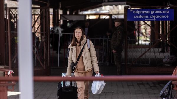 Uma jovem é retratada enquanto refugiados da Ucrânia desembarcam de um trem de Odessa e fazem fila para controles de passaporte ao chegarem à estação ferroviária em Przemysl, sudeste da Polônia, 6 de abril de 2022 - Sputnik Brasil