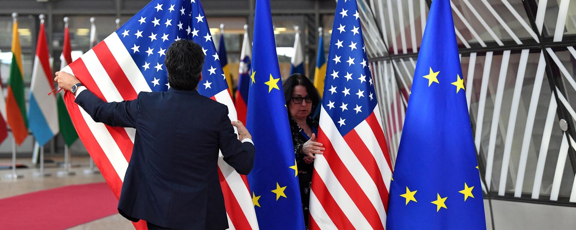 Bandeiras dos EUA e da União Europeia são preparadas para a chegada de Joe Biden, presidente dos EUA, à cúpula da União Europeia na sede do bloco, em Bruxelas, na Bélgica, em 24 de março de 2022 - Sputnik Brasil, 1920, 02.10.2022