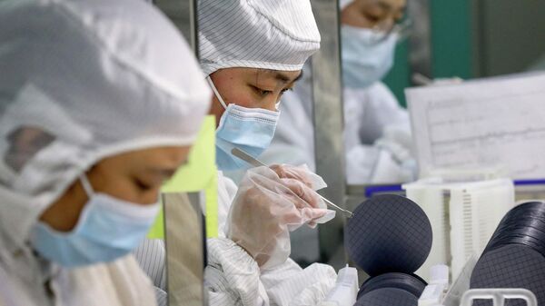 Funcionários fabricam chips em uma fábrica da Jiejie Semiconductor Company em Nantong, na província de Jiangsu, leste da China, em 17 de março de 2021 - Sputnik Brasil
