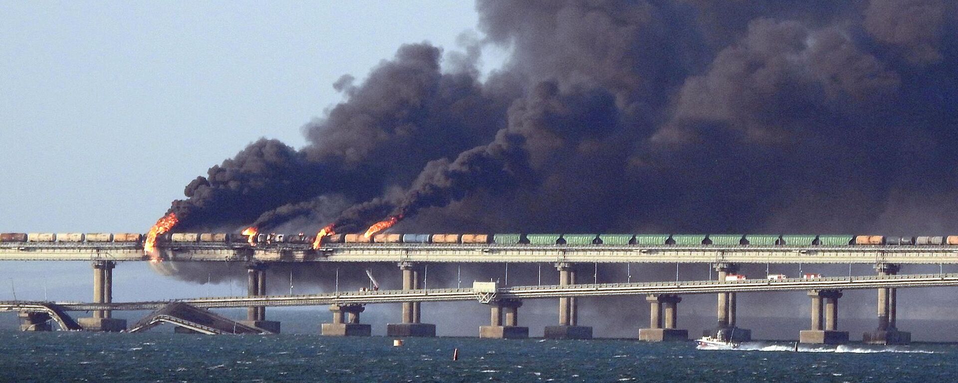 Fumaça preta sobe de um incêndio na ponte de Kerch que liga a Crimeia à Rússia, depois que um caminhão explodiu, perto de Kerch, em 8 de outubro de 2022 - Sputnik Brasil, 1920, 08.10.2022