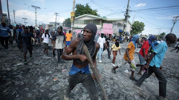 Um manifestante carrega um pedaço de madeira simulando uma arma durante um protesto exigindo a renúncia do primeiro-ministro Ariel Henry, na área de Petion-Ville, em Porto Príncipe, Haiti, 3 de outubro de 2022 - Sputnik Brasil