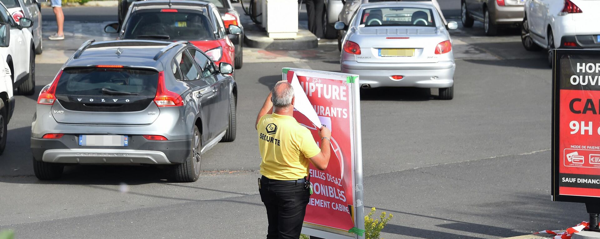 Um agente de segurança remove uma placa que diz falta de combustível enquanto motoristas fazem fila em um posto de gasolina Auchan em Perols, perto de Montpellier, no sul da França, 10 de outubro de 2022 - Sputnik Brasil, 1920, 10.10.2022