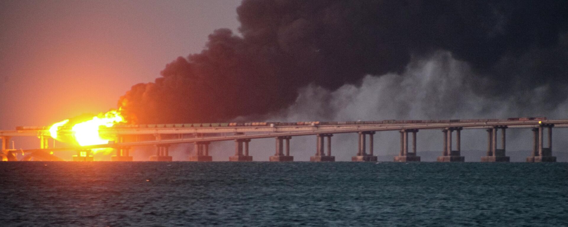 Chamas e fumaça sobem da Ponte da Crimeia, que conecta o restante da Rússia à península da Crimeia, após explosão, em 8 de outubro de 2022 - Sputnik Brasil, 1920, 01.03.2024