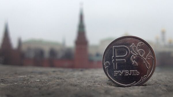 Uma moeda de rublo russo é retratada em frente ao Kremlin, no centro de Moscou, 6 de novembro de 2014 - Sputnik Brasil