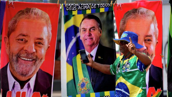 Apoiador vestido com as cores da bandeira do Brasil passa em frente a toalhas à venda com os rostos dos candidatos à Presidência Jair Bolsonaro (PL) e Luiz Inácio Lula da Silva (PT). Brasília, 23 de setembro de 2022 - Sputnik Brasil