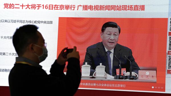Jornalista tira foto de tela mostrando Xi Jinping, presidente chinês, falando no centro de imprensa, na véspera do começo do 20º Congresso do Partido Comunista do país. Pequim, China, 15 de outubro de 2022 - Sputnik Brasil