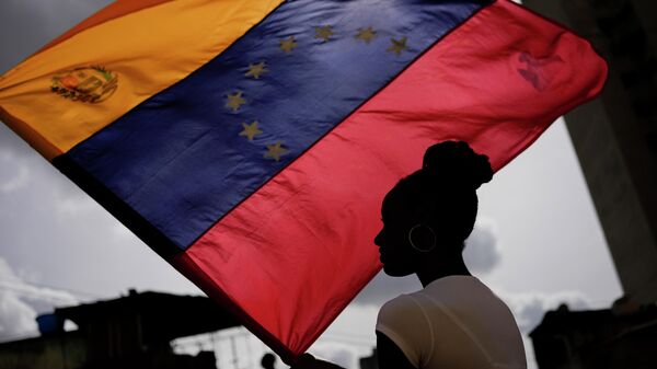 Mulher segura bandeira venezuelana durante a festa de São João Batista, no bairro de San Agustín, em Caracas, em 24 de junho de 2022 - Sputnik Brasil