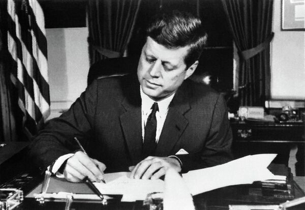 Em 22 de outubro, o presidente dos EUA, John Kennedy, anunciou um bloqueio naval a Cuba e, dois dias depois, a ilha foi cercada por 200 navios da Marinha dos EUA. O bloqueio foi acompanhado por aviões militares que controlavam a situação a partir do ar. Em 25 de outubro, os Estados Unidos estavam totalmente preparados para a guerra.Na foto: John Kennedy assina a ordem de bloqueio naval de Cuba, 23 de outubro de 1962. - Sputnik Brasil