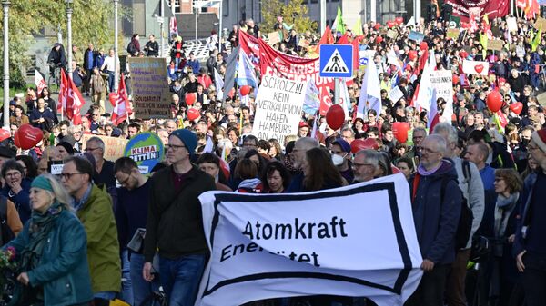 Pessoas marcham durante uma manifestação convocada por associações sociais, sindicatos e organizações ambientalistas sob o lema 'Solidário através da crise - criar seguridade social e acabar com a dependência de combustíveis fósseis', em 22 de outubro de 2022 em Berlim. - Sputnik Brasil