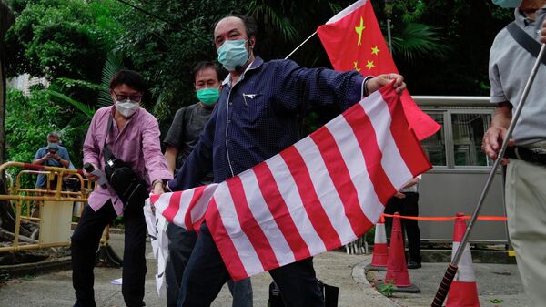 Apoiadores pró-chineses rasgam bandeira nacional dos EUA junto do consulado-geral do país norte-americano em Hong Kong, China, 3 de agosto de 2022 - Sputnik Brasil