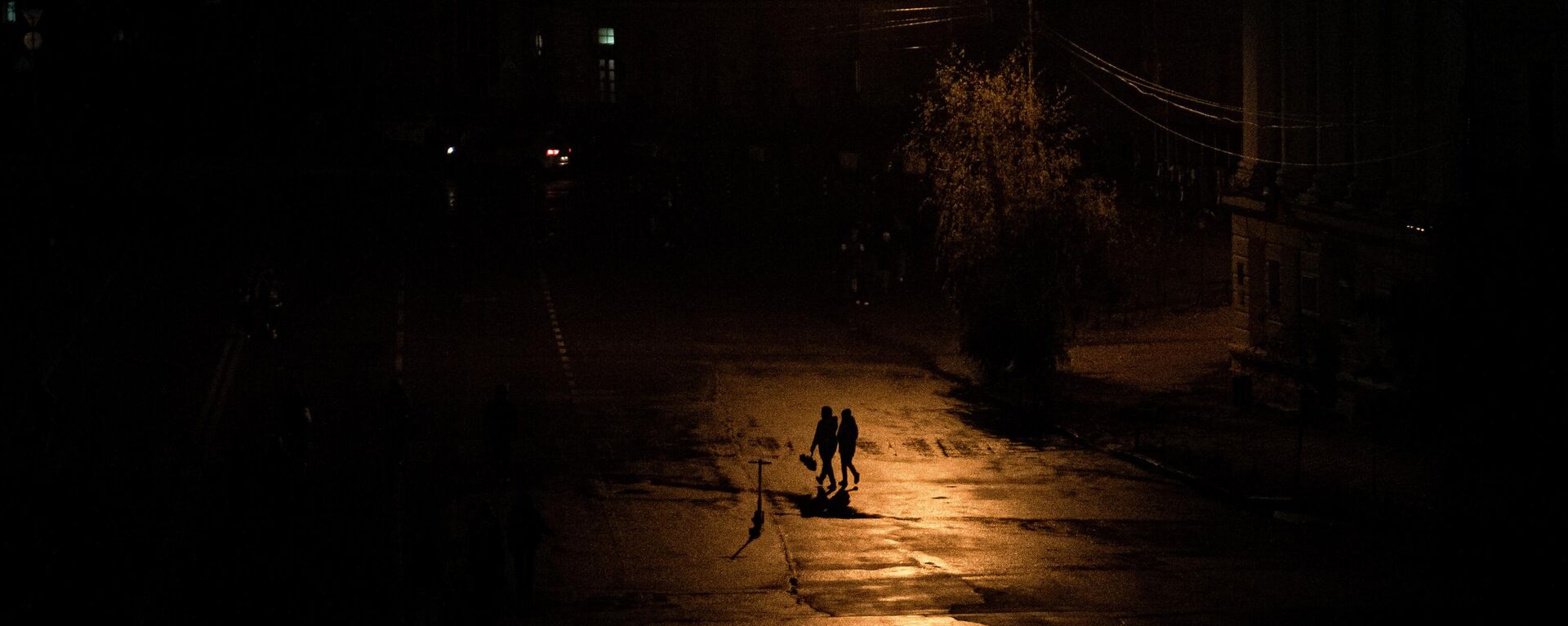 Pessoas caminham em escuro parcial durante blecaute em Kiev, capital da Ucrânia, em 6 de novembro de 2022 - Sputnik Brasil, 1920, 07.11.2022