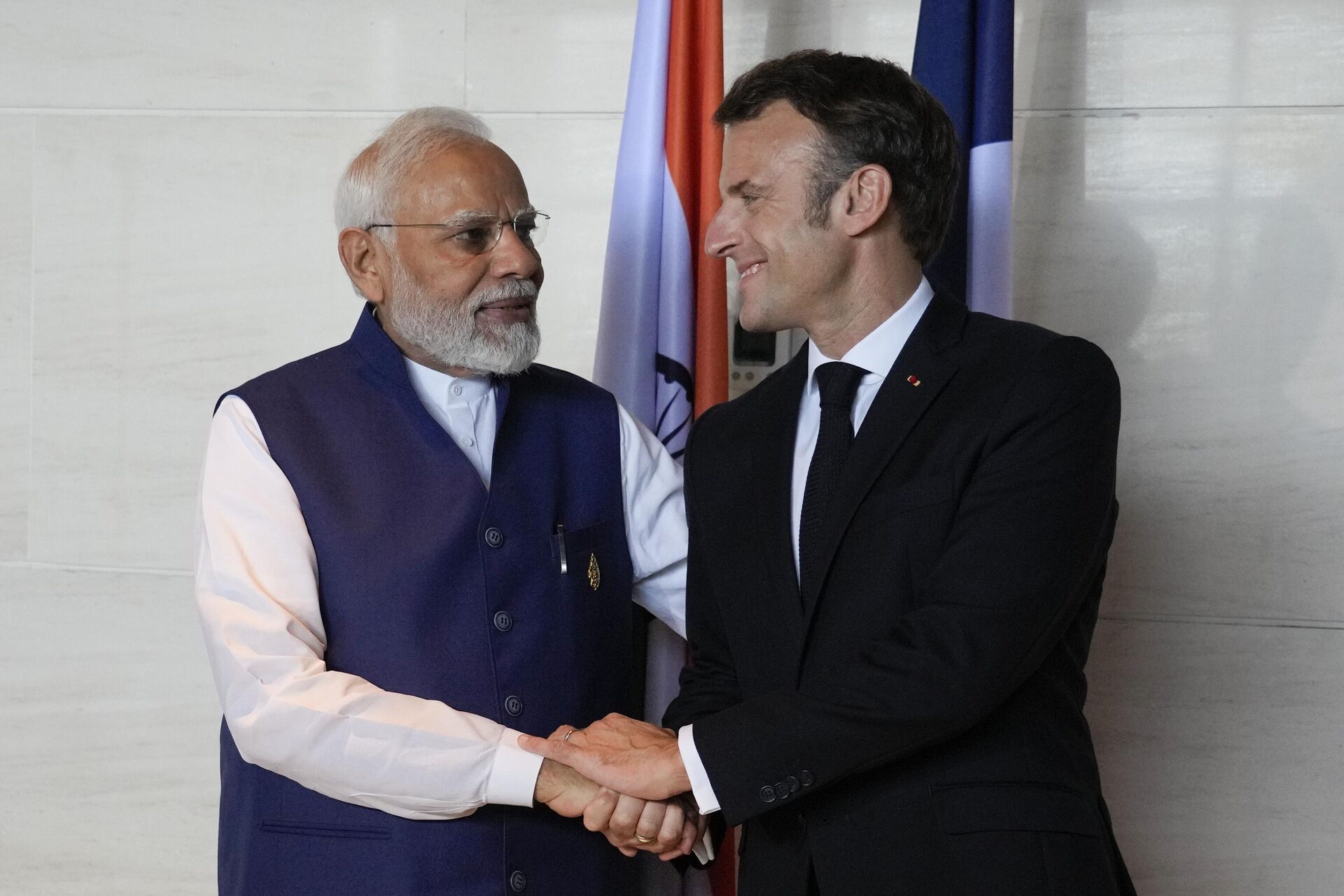 O primeiro-ministro da Índia, Narendra Modi (E) e o presidente francês, Emmanuel Macron, apertam as mãos durante uma reunião bilateral à margem da Cúpula do G20 em Nusa Dua, Bali, Indonésia, 16 de novembro de 2022 - Sputnik Brasil, 1920, 16.11.2022