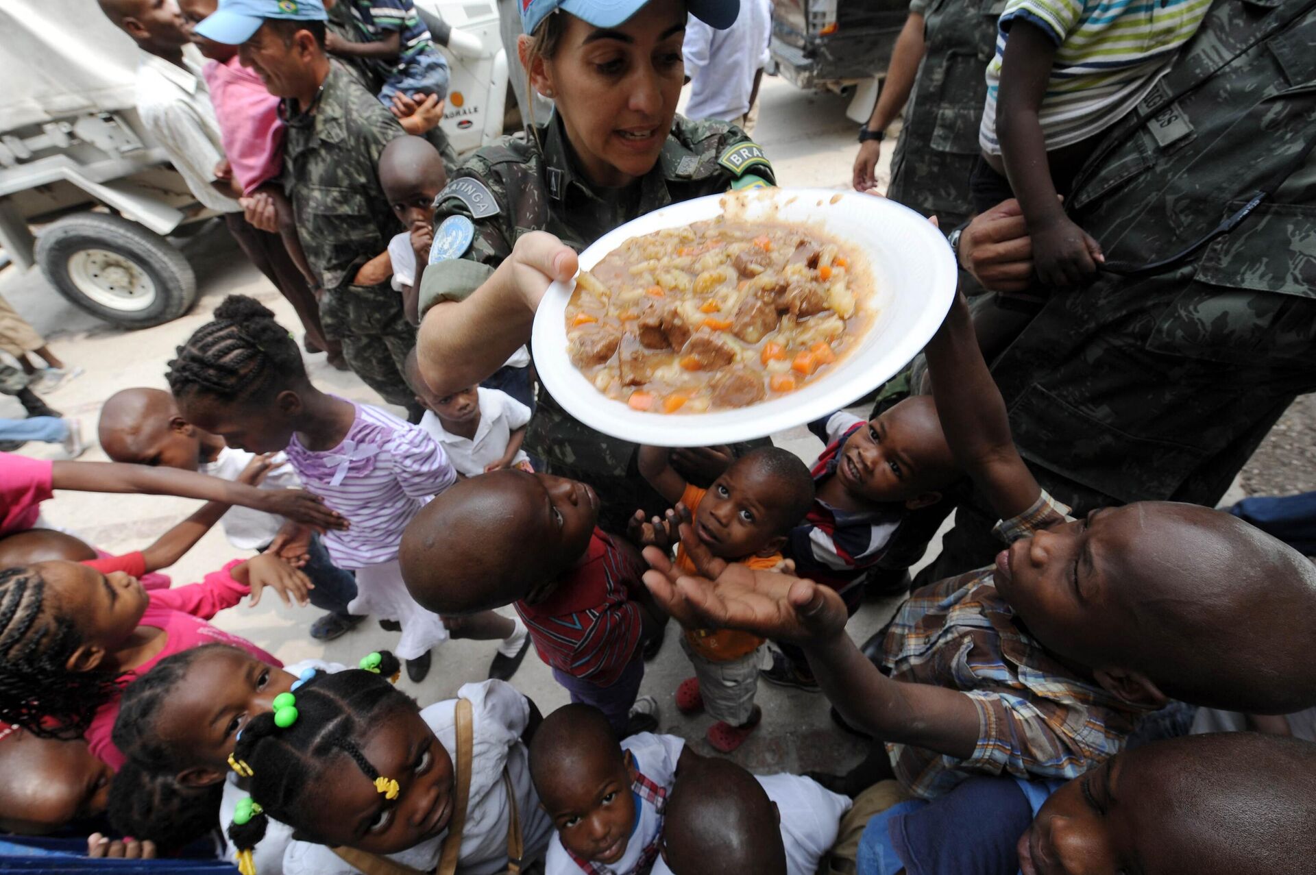 Soldada brasileira da MINUSTAH providencia comida a criança em orfanato no Haiti, 3 de março de 2013 - Sputnik Brasil, 1920, 17.11.2022