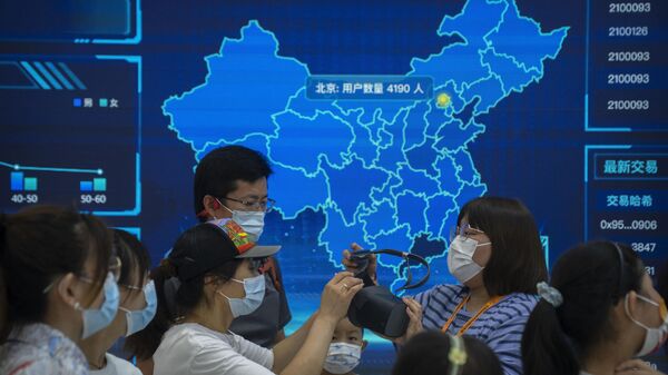 Visitantes usando máscaras se preparam para colocar um fone de ouvido de realidade virtual em frente a um mapa digital da China em um estande na Feira Internacional de Comércio de Serviços da China (CIFTIS) em Pequim, 3 de setembro de 2022 - Sputnik Brasil