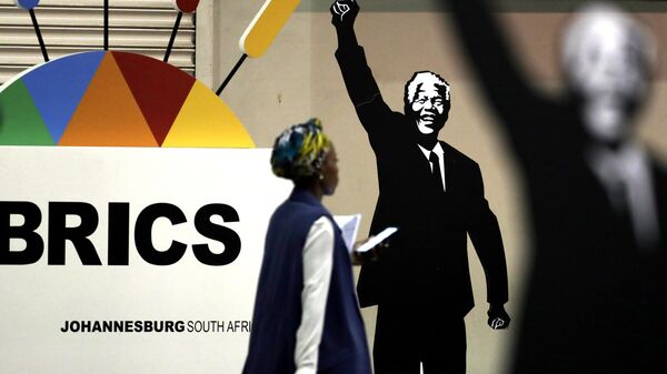 Mulher passa diante de cartaz em homenagem ao ex-presidente da África do Sul Nelson Mandela durante encontro do BRICS em Joanesburgo, na África do Sul, em 27 de julho de 2018 - Sputnik Brasil