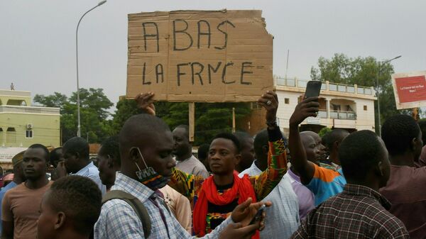 Homem segura cartaz dizendo Abaixo a França durante ação de protesto contra a presença militar do país europeu no Níger em Niameu, 18 de setembro de 2022 - Sputnik Brasil