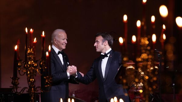 Joe Biden (à esquerda) e Emmanuel Macron (à direita), presidentes dos EUA e da França, respectivamente, apertam as mãos antes de um brinde na Casa Branca, Washington, EUA, 1º de dezembro de 2022 - Sputnik Brasil