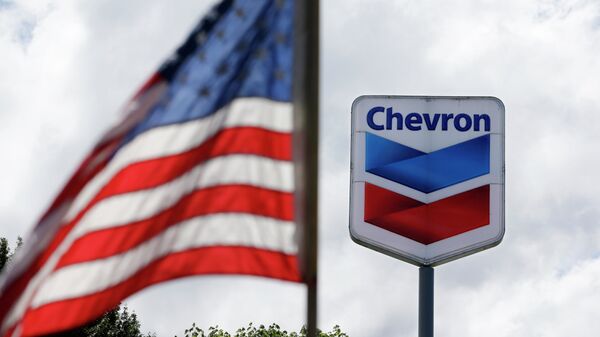 A bandeira dos Estados Unidos tremula em frente a um posto de gasolina da Chevron em Blaine, Washington, EUA, 23 de maio de 2013 - Sputnik Brasil