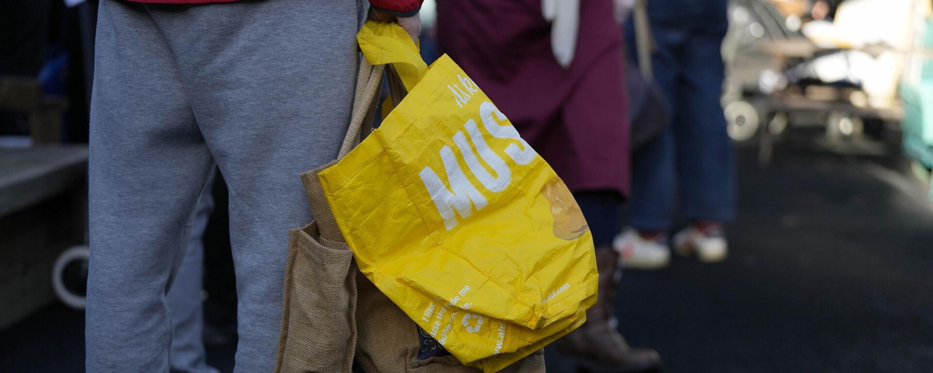 Clientes fazem fila com sacolas vazias enquanto esperam a abertura da despensa comunitária em Vauxhall, Londres, 16 de novembro de 2022 - Sputnik Brasil, 1920, 02.12.2022