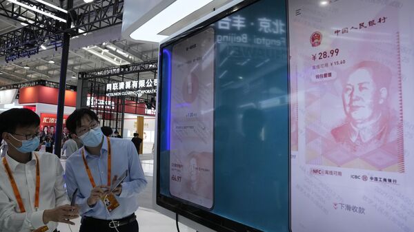 Trabalhadores demonstram o uso do e-CNY, uma versão digital do yuan chinês, durante a Feira Internacional de Comércio de Serviços da China (CIFTIS) em Pequim, China (foto de arquivo) - Sputnik Brasil