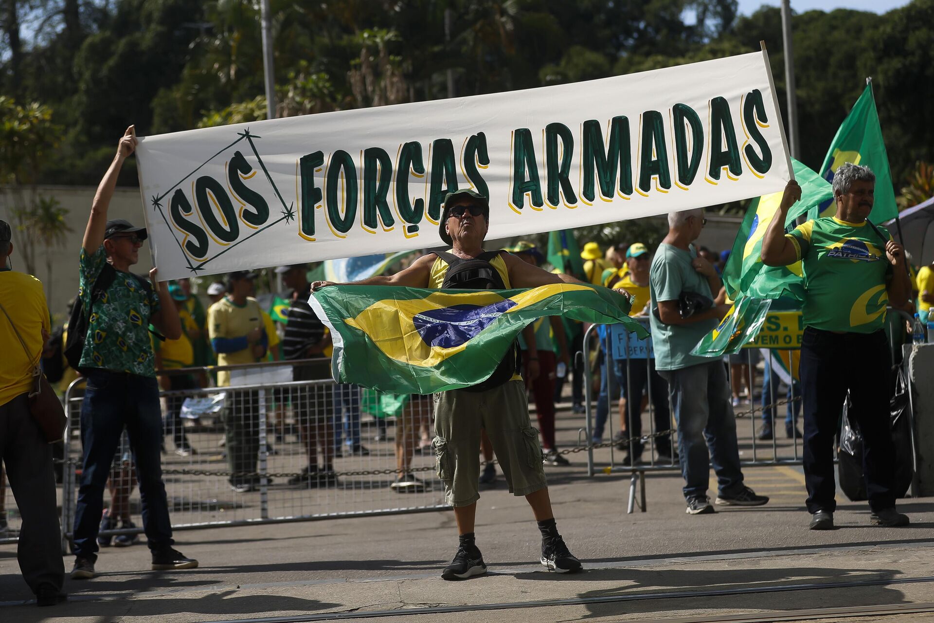 Apoiadores do presidente brasileiro Jair Bolsonaro seguram um cartaz com a mensagem em português: S.O.S Forças Armadas durante um protesto contra o resultado das eleições presidenciais, 15 de novembro de 2022 - Sputnik Brasil, 1920, 25.02.2023