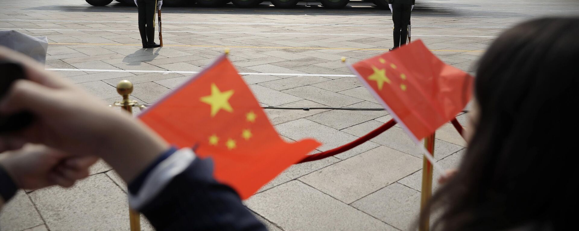 Espetadores acenam com bandeiras chinesas enquanto veículos militares DF-41, capazes de transportar ogivas nucleares, passam durante desfile por ocasião do 70º aniversário da fundação do Partido Comunista chinês, Pequim, 1 de outubro de 2019 - Sputnik Brasil, 1920, 07.03.2023