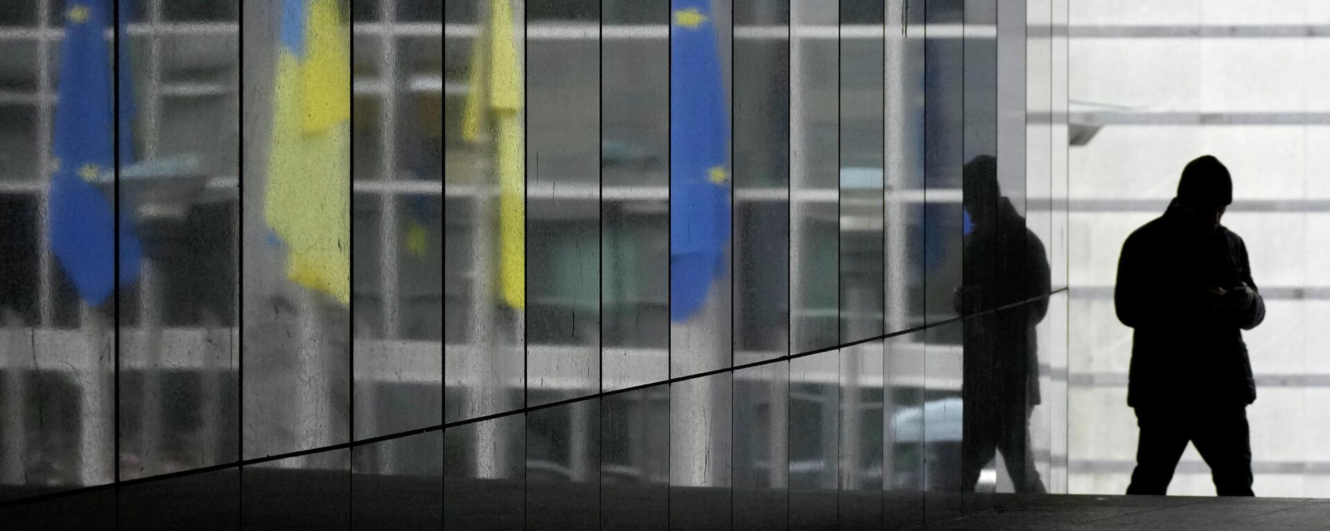 As bandeiras da Ucrânia e da União Europeia são refletidas em uma parede de mármore enquanto um visitante caminha antes de uma sessão plenária extraordinária sobre a Ucrânia no Parlamento Europeu em Bruxelas, 1º de março de 2022 - Sputnik Brasil, 1920, 12.12.2022