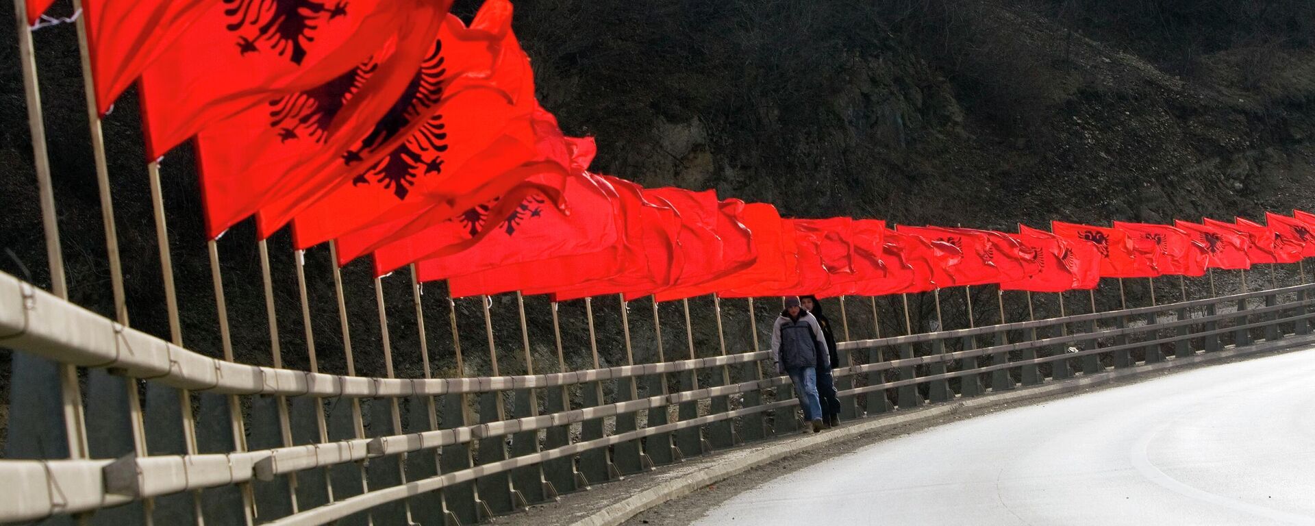 Kosovares cruzam  ponte decorada com dezenas de bandeiras nacionais albanesas um ano depois que o território de maioria albanesa declarou a independência da Sérvia de forma desafiadora, Kosovo, 16 de fevereiro de 2009 - Sputnik Brasil, 1920, 15.12.2022