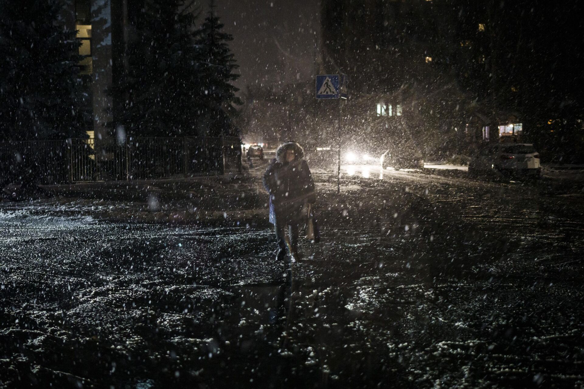 Uma mulher atravessa a rua durante uma nevasca, enquanto a falta de energia continua em Kiev, Ucrânia, 16 de dezembro de 2022 - Sputnik Brasil, 1920, 20.12.2022
