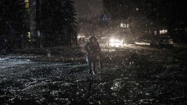 Uma mulher atravessa a rua durante uma nevasca, enquanto a falta de energia continua em Kiev, Ucrânia, 16 de dezembro de 2022 - Sputnik Brasil