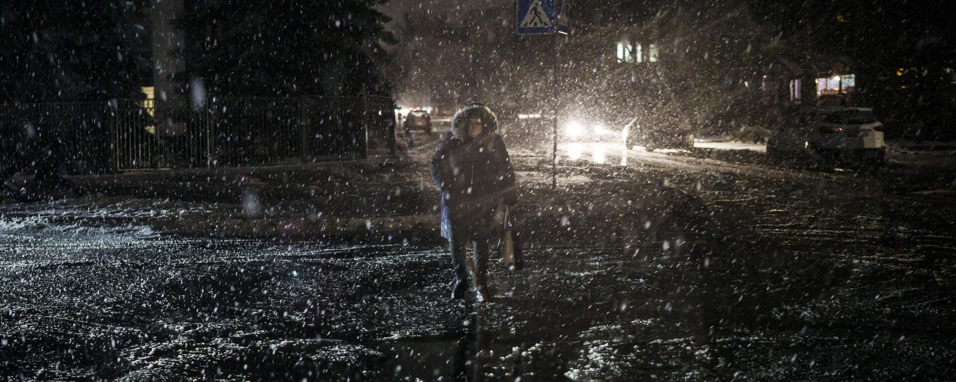 Uma mulher atravessa a rua durante uma nevasca, enquanto a falta de energia continua em Kiev, Ucrânia, 16 de dezembro de 2022 - Sputnik Brasil, 1920, 05.02.2023