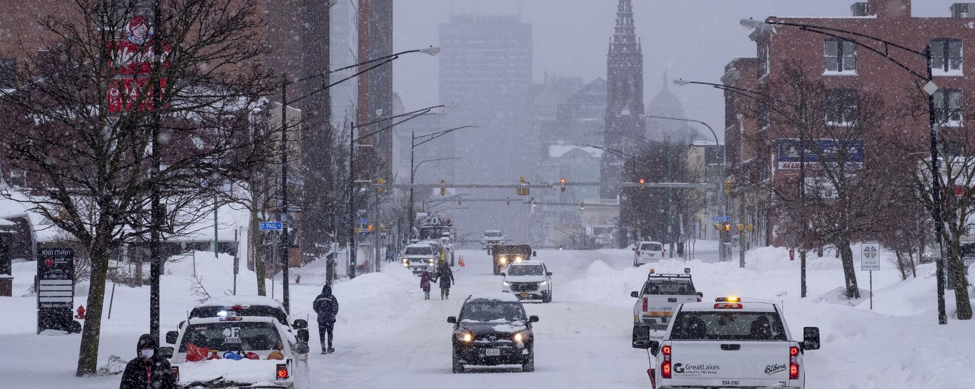 Pessoas e veículos circulam pela rua principal da cidade de Buffalo, em Nova York, em 26 de dezembro de 2022, depois que uma enorme tempestade de neve cobriu a cidade - Sputnik Brasil, 1920, 26.12.2022