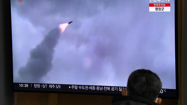 Homem observa tela televisiva mostrando imagens do lançamento de míssil da Coreia do Norte em uma estação ferroviária em Seul, Coreia do Sul, 31 de dezembro de 2022 - Sputnik Brasil