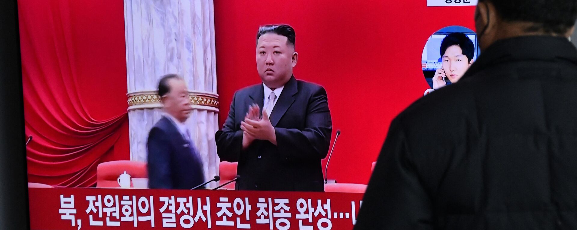 Um homem assiste a uma tela de televisão exibindo um noticiário com imagens de arquivo do líder norte-coreano Kim Jong-un, em uma estação ferroviária em Seul, 31 de dezembro de 2022 - Sputnik Brasil, 1920, 02.01.2023
