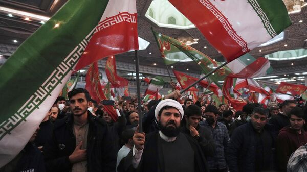 Enlutados agitam bandeiras iranianas e islâmicas durante cerimônia que marca o aniversário da morte do general Qassem Soleimani, da Guarda Revolucionária, na Grande Mesquita Imam Khomeini, em Teerã. Irã, 3 de janeiro de 2023 - Sputnik Brasil