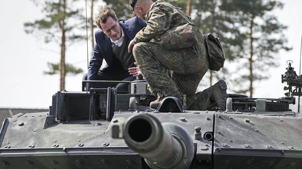 O governador Hendrick Wuest senta-se em um tanque Leopard durante uma visita à base militar Field Marshal Rommel Barracks em Augustdorf, Alemanha, 30 de março de 2022 - Sputnik Brasil