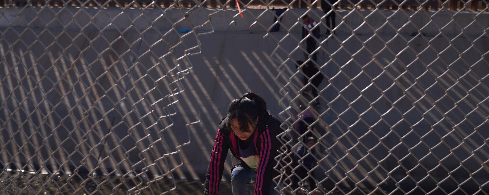 Migrantes entram ilegalmente nos Estados Unidos vindos do México por meio de um buraco aberto na cerca da fronteira em El Paso, Texas, EUA, 21 de dezembro de 2022  - Sputnik Brasil, 1920, 08.01.2023
